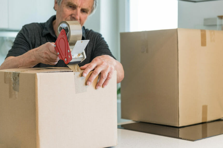Man taping moving box shut